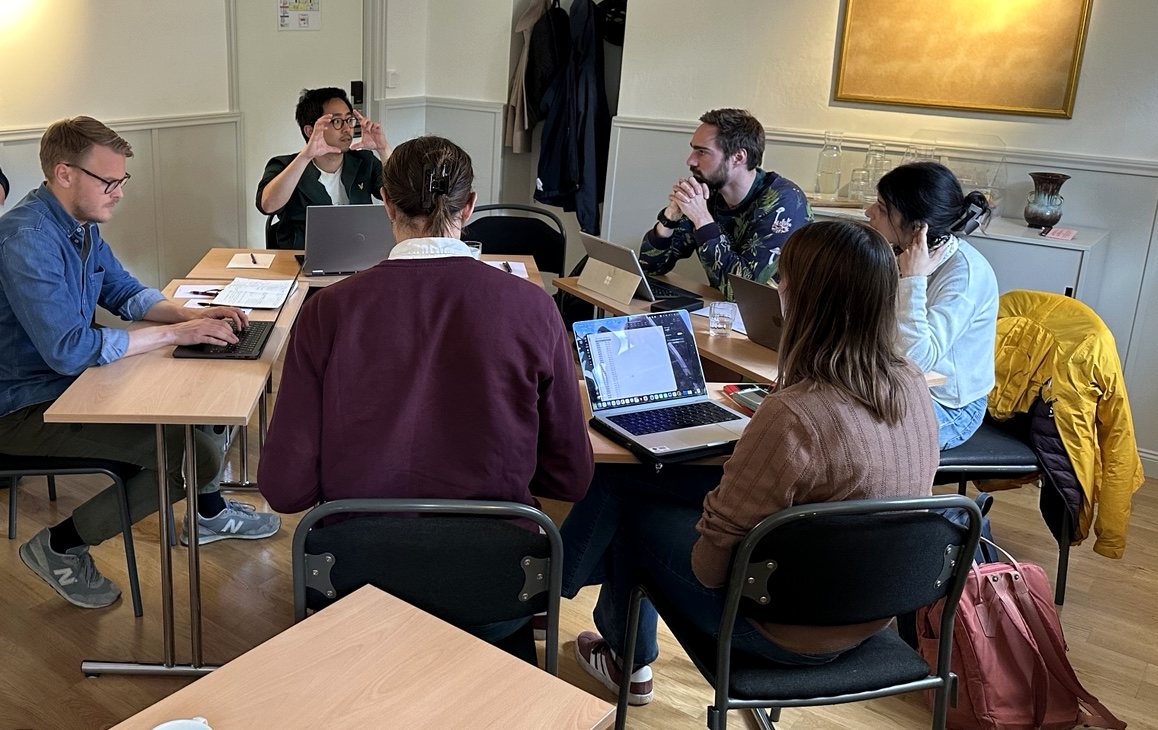 Lab members collaborating around laptops during a modelling workshop
